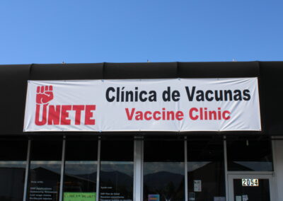 A sign that reads "Únete, Clínica de Vacunas Vaccine Clinic"