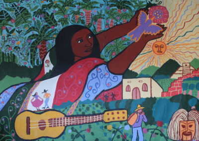 A mural of a woman draped in the Mexican flag holding a bird, pointing at the sun. She has a guitar, a home, and a farmworker underneath her.