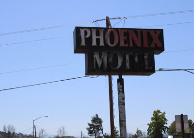 A phot of a burnt hotel sign that reads "Phoenix Motel"
