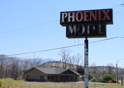 A phot of a burnt hotel sign that reads "Phoenix Motel"