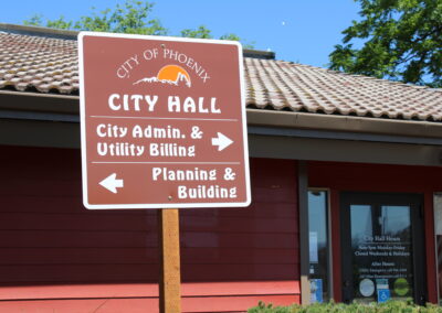 A sign that reads "Phoenix City Hall" with arrows pointing to the City Admin building and the Planning and Building building.