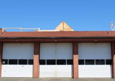 A photo of a firestation with three doors.