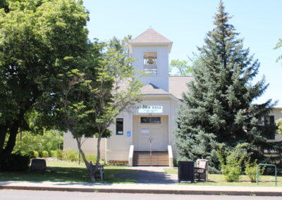A photo of Talent City Hall, it is a small, white building with a bell on top.