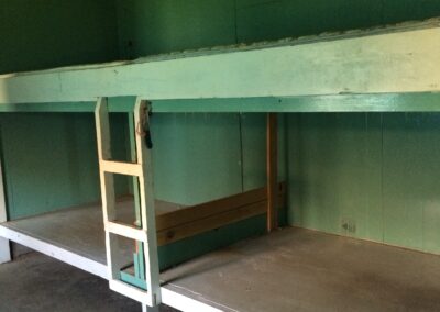 Wooden bed in the form of bunkbeds. It is green.